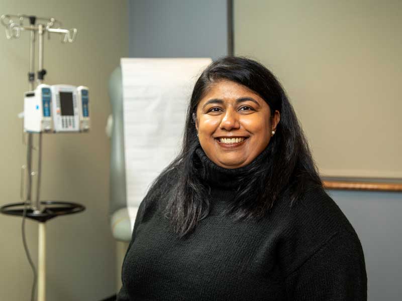 a smiling health practitioner in a room in a health clinic